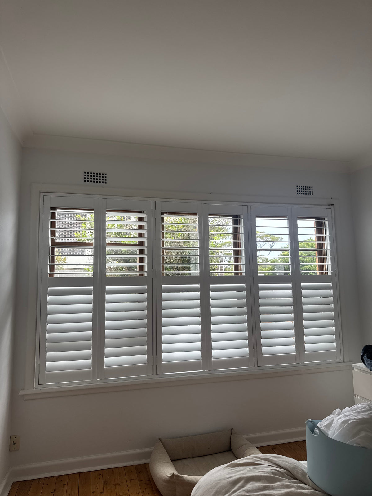 White plantation shutters fitted across a Willoughby bedroom window
