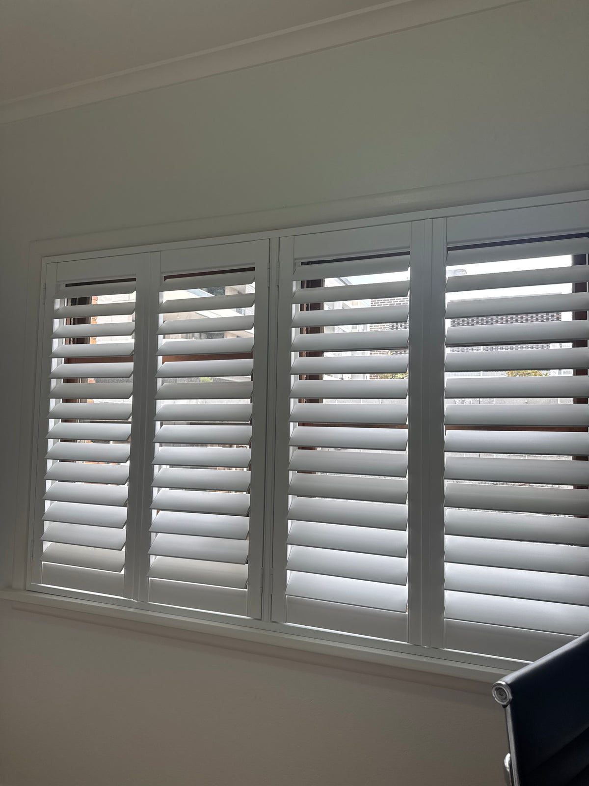 Close view of white plantation shutters in a Willoughby apartment